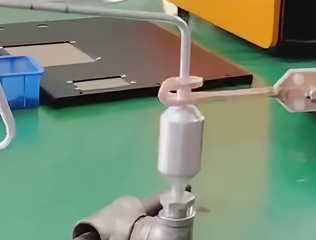 鋁管鋁儲液器正在進行釬焊，用的是手持式高頻感應焊機